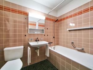 a bathroom with a toilet and a sink and a bath tub at Apartment Ringstrasse Apt 412 by Interhome in Leukerbad