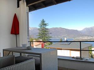 PiazzognaにあるApartment Miralago - Utoring-5 by Interhomeの山の景色を望むバルコニー(テーブル、椅子付)