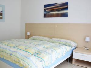 Schlafzimmer mit einem Bett mit einem Kopfteil aus Holz in der Unterkunft Apartment Corallo - Utoring-22 by Interhome in Ascona