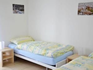 a bed in a room with two twin beds at Apartment Residenza Corallo-22 by Interhome in Ascona