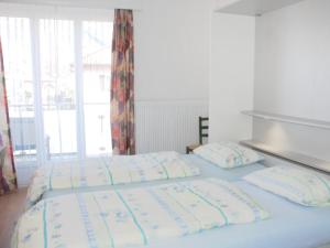 two twin beds in a room with a window at Apartment Residenza Corallo-7 by Interhome in Ascona