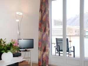 a living room with a computer and a window at Apartment Residenza Corallo-7 by Interhome in Ascona