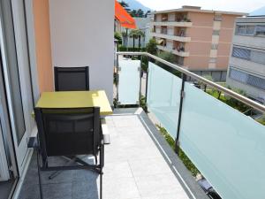 a balcony with a table and chairs on a building at Apartment Residenza Corallo-7 by Interhome in Ascona