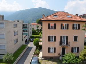 an apartment building with a mountain in the background at Apartment Residenza Corallo-7 by Interhome in Ascona +7 photos