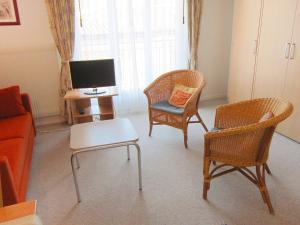 uma sala de estar com duas cadeiras e uma televisão em Apartment Corallo - Utoring-10 by Interhome em Ascona
