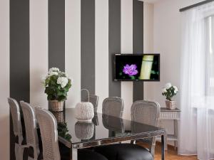 ein Esszimmer mit einem Tisch und Stühlen sowie einem TV in der Unterkunft Apartment Suite by Interhome in Ascona