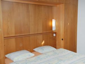 ein Schlafzimmer mit einem Bett und einer Holzwand in der Unterkunft Apartment Corallo - Utoring-20 by Interhome in Ascona