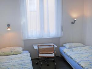 1 Schlafzimmer mit 2 Betten, einem Stuhl und einem Fenster in der Unterkunft Apartment Corallo - Utoring-20 by Interhome in Ascona