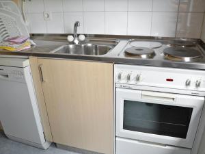 una cucina con fornelli e lavello di Apartment Residenza Corallo-20 by Interhome ad Ascona Altre 14 foto