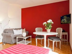 アスコナにあるApartment Double Room-3 by Interhomeの白いテーブルと赤い壁のリビングルーム