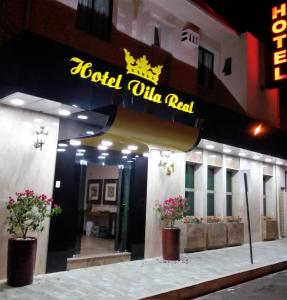 Hotel Vila Real في أراساتوبا: فندق فيه لافته على جانب مبنى