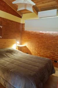 une chambre avec un lit dans une pièce aux murs en bois dans l'établissement Anlupa Departamento, à El Bolsón