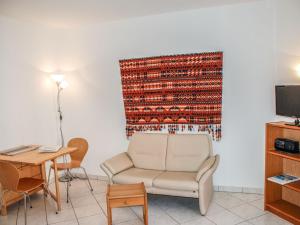 ein Wohnzimmer mit einem Stuhl und einem Tisch in der Unterkunft Apartment Corallo - Utoring-5 by Interhome in Ascona