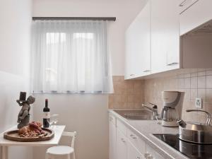 a white kitchen with a plate of food on a counter at Apartment Suite-16 by Interhome in Ascona