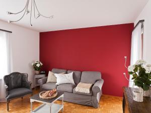 ein Wohnzimmer mit einem Sofa und einer roten Wand in der Unterkunft Apartment Suite by Interhome in Ascona