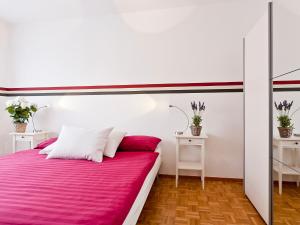 アスコナにあるApartment Suite by Interhomeのベッドルーム1室(ピンクのシーツとテーブル2台付)