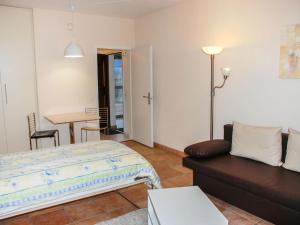 ein Schlafzimmer mit einem Bett, einem Sofa und einem Tisch in der Unterkunft Apartment Corallo - Utoring-25 by Interhome in Ascona