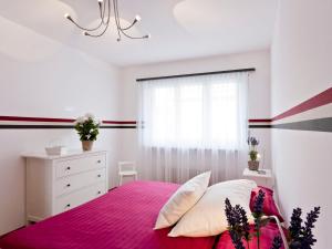 ein Schlafzimmer mit einem rosa Bett und einem Fenster in der Unterkunft Apartment Michèle - Utoring-11 by Interhome in Ascona
