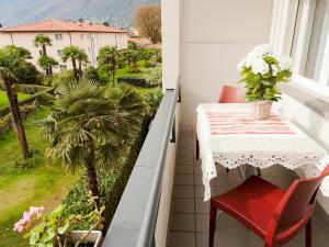einen Balkon mit einem Tisch und einer Palme in der Unterkunft Apartment Double Room-5 by Interhome in Ascona