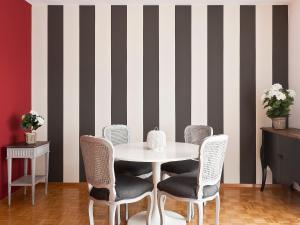 ein Esszimmer mit einem Tisch, Stühlen und einer gestreiften Wand in der Unterkunft Apartment Junior Suite-8 by Interhome in Ascona
