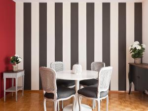 a dining room with a table and chairs and striped wall at Apartment Junior Suite-9 by Interhome in Ascona