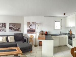 eine Küche und ein Wohnzimmer mit einem Sofa und einem Tisch in der Unterkunft Apartment Casa Tavaun A11 by Interhome in Flims