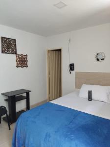 1 dormitorio con 1 cama con manta azul y escritorio en Hotel Mirador Plaza, en Pereira