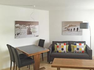 ein Wohnzimmer mit einem Sofa und einem Tisch in der Unterkunft Apartment Casa Tavaun A14 by Interhome in Flims