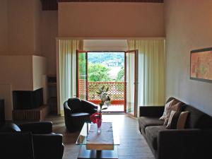 uma sala de estar com um sofá e uma mesa em Apartment Parcolago - Utoring-75 by Interhome em Caslano