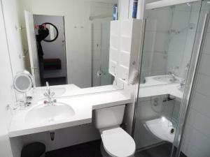 um banheiro com uma pia, um vaso sanitário e um espelho em Apartment Apt A 084 by Interhome em Disentis