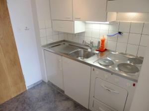 eine kleine Küche mit einer Spüle und einer Theke in der Unterkunft Apartment Promenade - Utoring-60 by Interhome in Arosa
