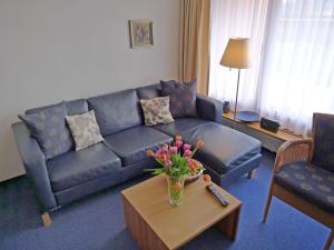 ein Wohnzimmer mit einem Sofa und einem Tisch mit Blumen in der Unterkunft Apartment Promenade - Utoring-68 by Interhome in Arosa