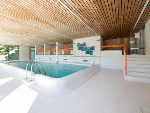einen Pool in einem Gebäude mit Holzdecke in der Unterkunft Apartment Guardaval - Utoring-15 by Interhome in Davos