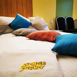 a large bed with colorful pillows on top of it at Elemels Planet in Ustroń