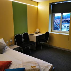 a hotel room with a bed and a desk and chairs at Elemels Planet in Ustroń