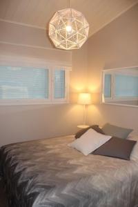 sypialnia z łóżkiem, lampką i oknami w obiekcie Villa Lakia w mieście Syöte
