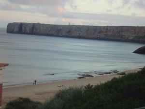 a person standing on a beach near the ocean at Mira Fortaleza in Sagres