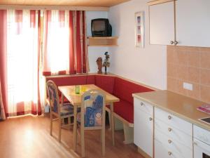 cocina con mesa y sillas y TV en Apartment Gasthof Almluft-4 by Interhome, en Stummerberg