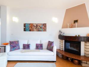 uma sala de estar com um sofá branco e uma lareira em Apartment Stefania - VNA370 by Interhome em Varenna