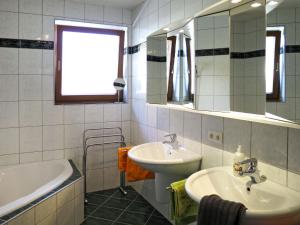 W łazience znajduje się umywalka, wanna, umywalka i lustro. w obiekcie Apartment Neurauter-1 by Interhome w mieście Fügen