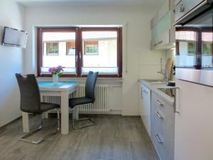 uma cozinha com uma mesa e duas cadeiras e uma janela em Apartment Pension Himmelsbach by Interhome em Welschensteinach