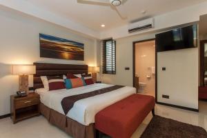 a bedroom with a large bed with a red ottoman at The Somerset Hotel in Male City