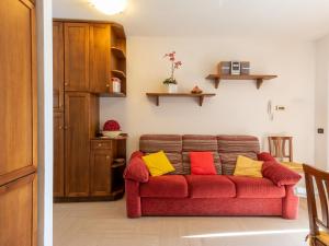 een rode bank met kleurrijke kussens in de woonkamer bij Holiday Home Rosa - VNA205 by Interhome in Perledo