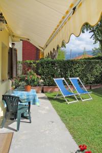 dwa krzesła i stół i krzesła pod parasolem w obiekcie Holiday Home Casetta Mosti by Interhome w mieście Marina di Massa