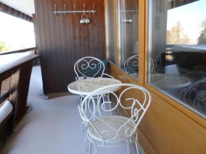una mesa blanca y sillas frente a una ventana en Studio Dixence 115 by Interhome, en Les Collons