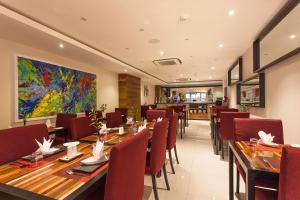 a restaurant with wooden tables and red chairs at The Somerset Hotel in Male City +79 photos