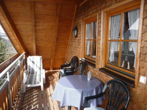 einen Tisch und Stühle auf der Veranda einer Hütte in der Unterkunft Apartment Biohof Herrenweg-2 by Interhome in Dreimühlen