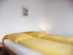 two beds in a room with yellow pillows at Apartment Biohof Herrenweg-2 by Interhome in Dreimühlen