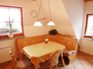 a dining room with a table with flowers on it at Apartment Biohof Herrenweg-2 by Interhome in Dreimühlen