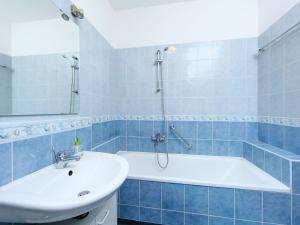baño de azulejos azules con bañera y lavamanos en Holiday Home Juglans 1 by Interhome, en Balatonakali